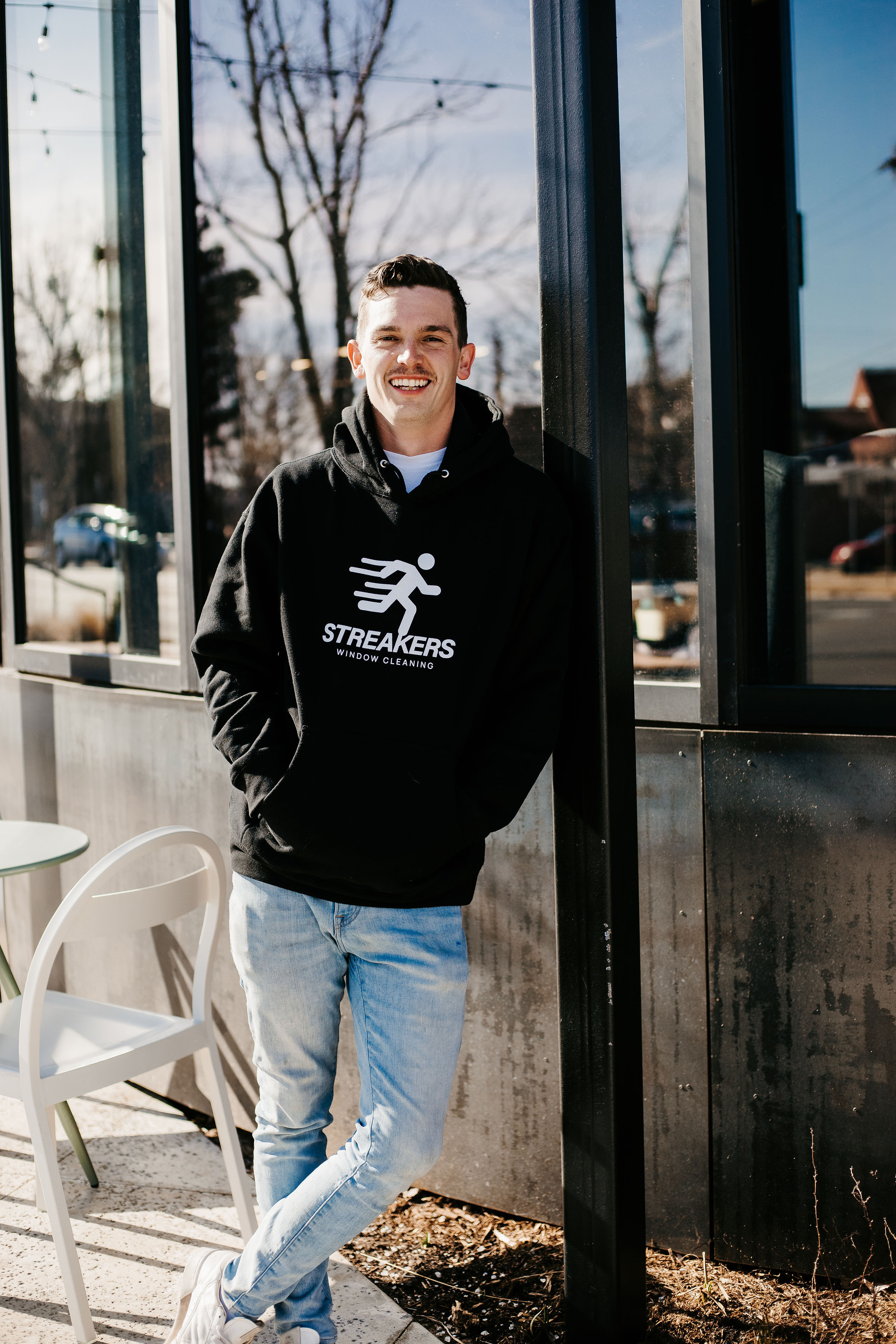 Timmy Riggs, owner of Streakers Window Cleaning, smiling outside a business in Oklahoma City